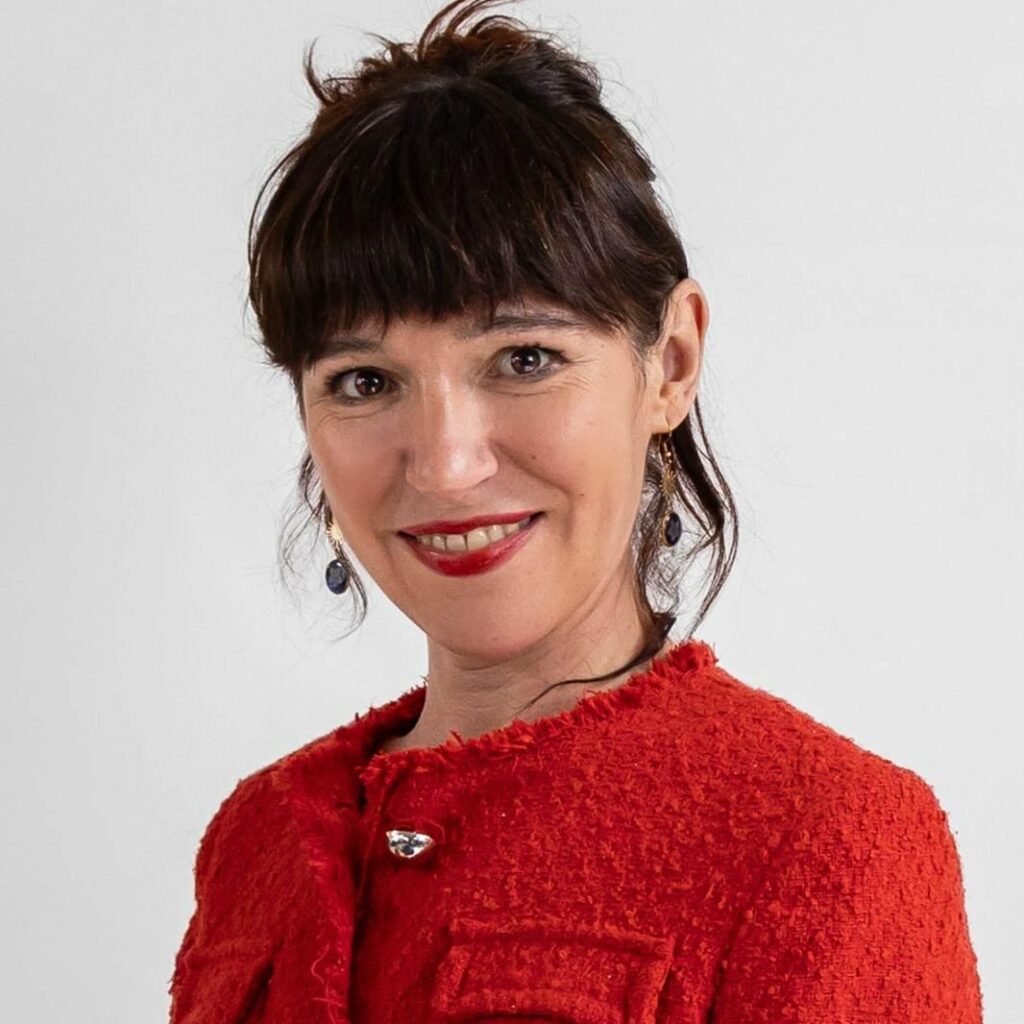 Photographie de Martha Peciña, portant une veste rouge.